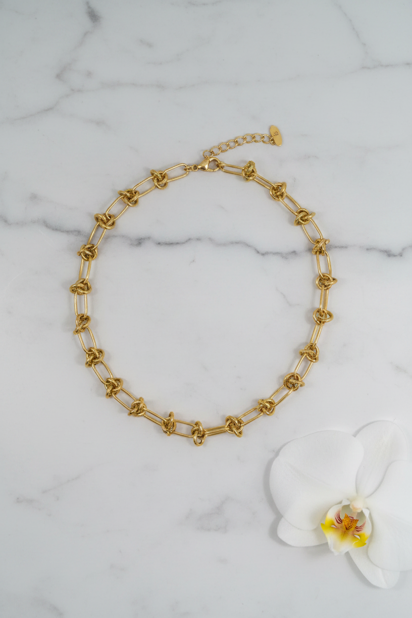 Collier nœuds dorés - Flat lay fond marbré